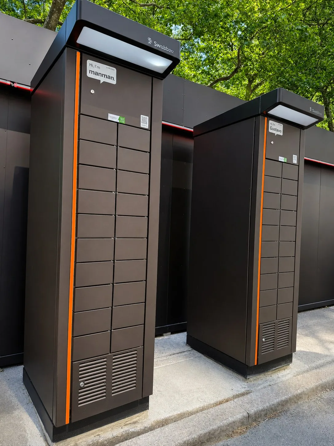 The same two cabinets seen from the pavement, the orange signal edge running down the front of each
