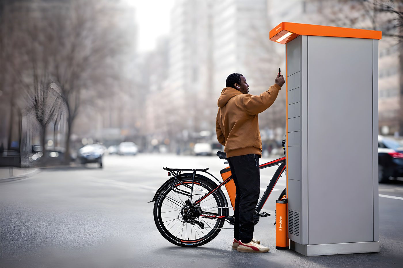 Un livreur utilise son téléphone à une station Swobbee à New York, son vélo électrique garé à côté